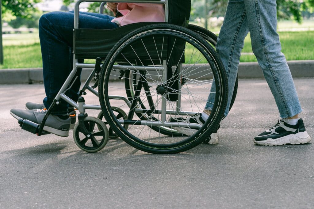 Close up of Legs of Person Walking with Person Sitting on Wheelchair